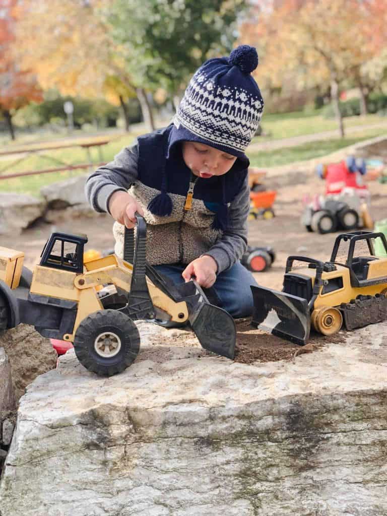 boy playing with tractors at playground