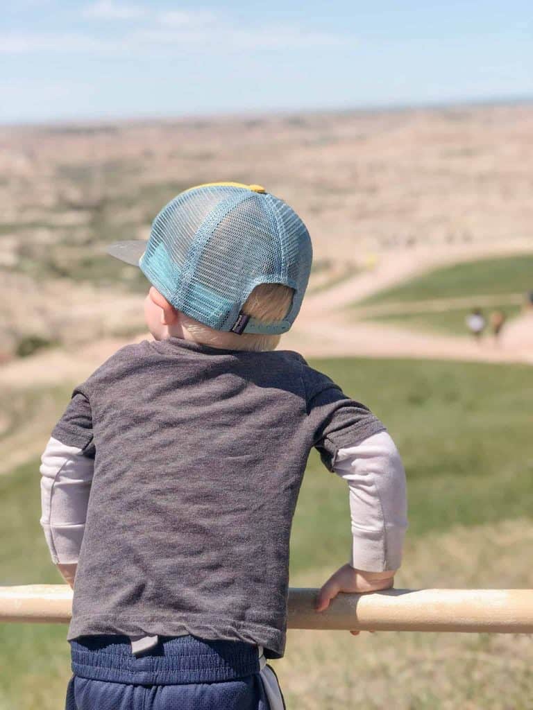 Child in hat looking over badlands