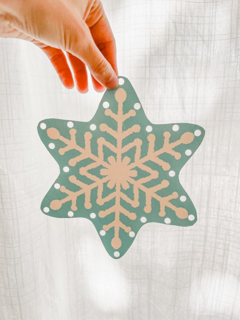 Snowflake sewing card held up in front a white background