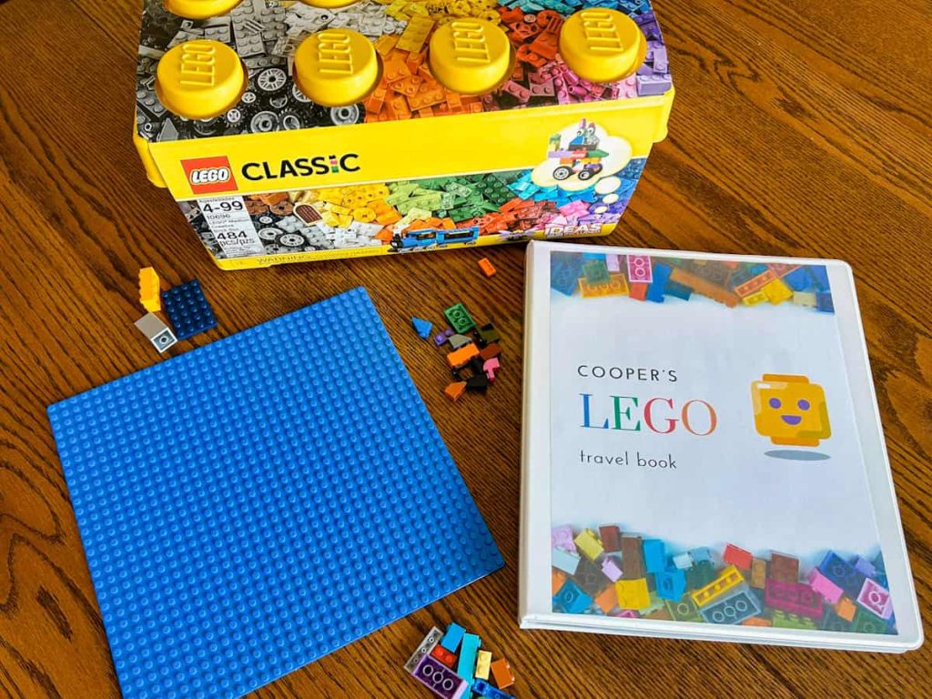 lego binder sitting on table with baseplate, large lego container and legos on table