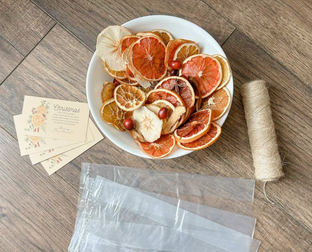 items to make christmas potpourri gift including bowl of dried fruit, clear bags, twine and free printable tag