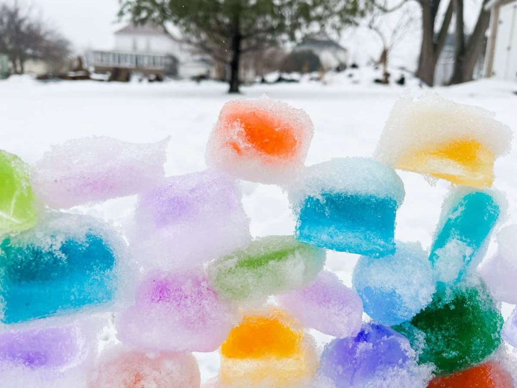 up close of colored ice cubes making a rainbow ice tower