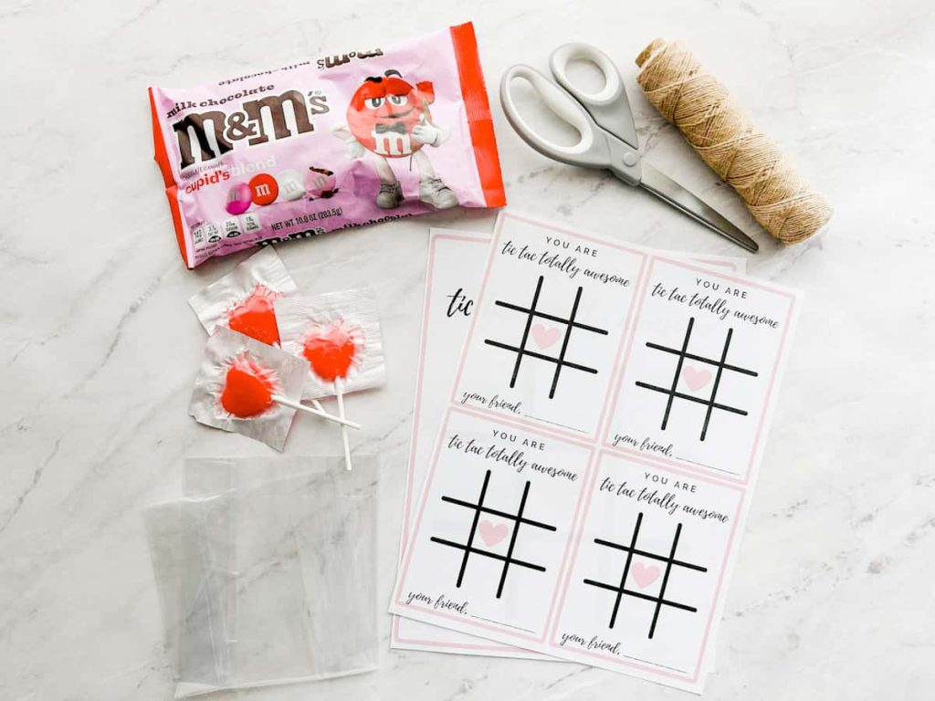 tic tac toe valentines card materials including printable, twine, scissors, suckers, clear bags and m&ms