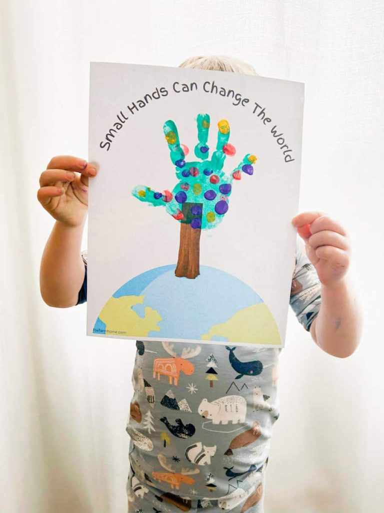 child holding their completed earth day handprint craft