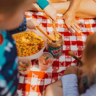 children on table cloth with gone fishing camping snack items in front of them
