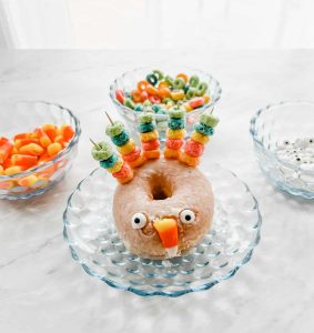 Turkey doughnut on a plate next to 3 bowls with ingredients