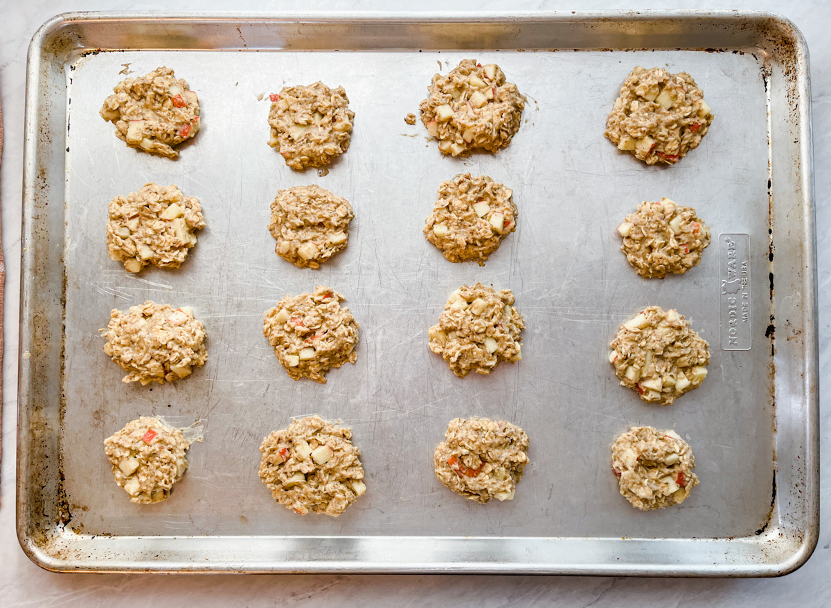 Apple breakfast cookie dough flattened on baking sheet on counter.