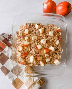 finished overnight oatmeal on table with apples and towel next to it