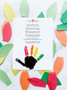 completed handprint turkey poem craft with leaves around it
