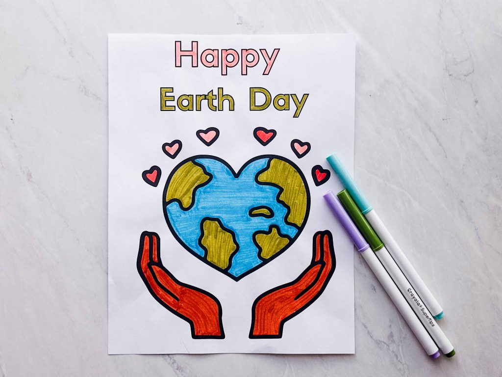 Happy Earth Day coloring sheet colored in on table with markers next to it