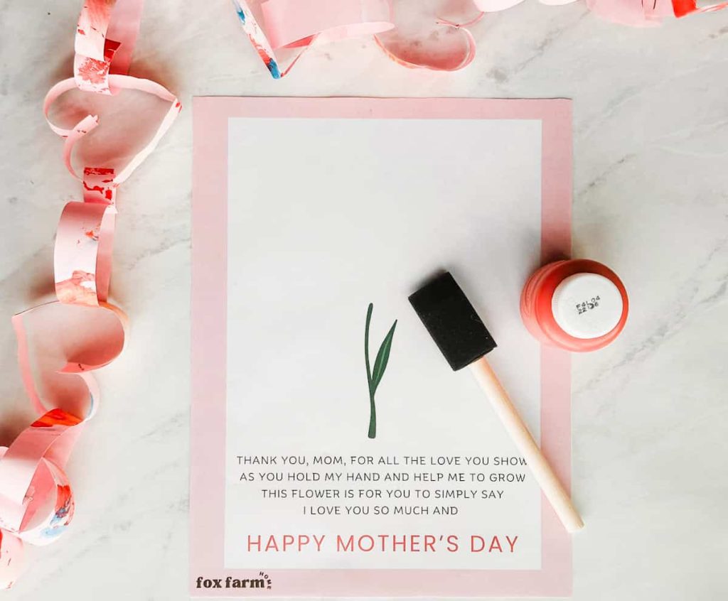Materials for the handprint craft including the free printable template, paint brush and paint
