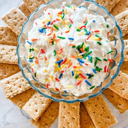 funfetti dip in bowl with graham crackers around it on a plate