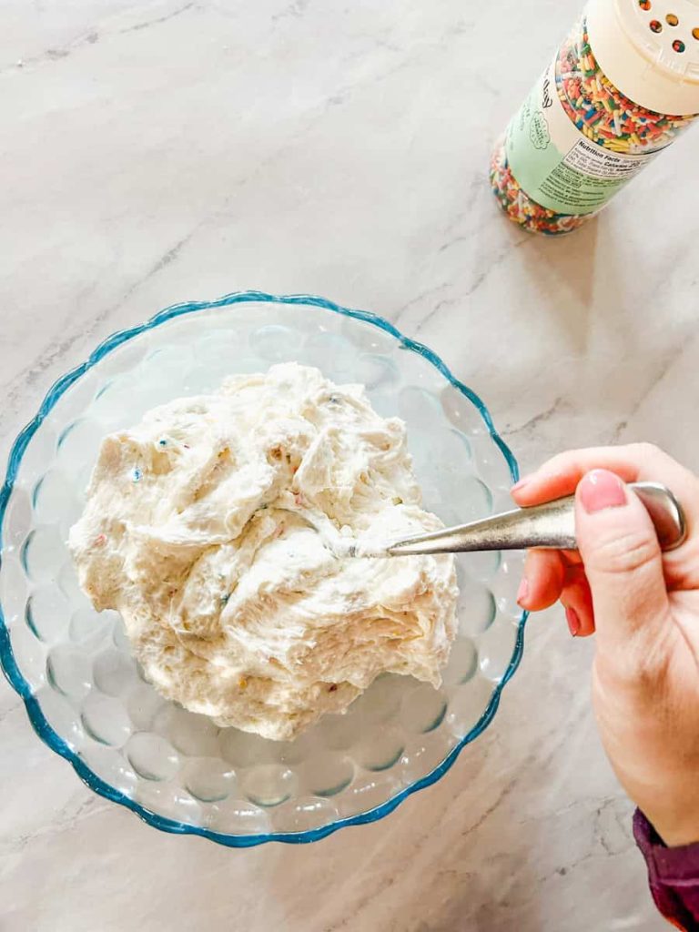 hand mixing ingredients in bowl on table