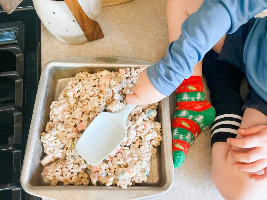 child pushing the lucky charms into the pan