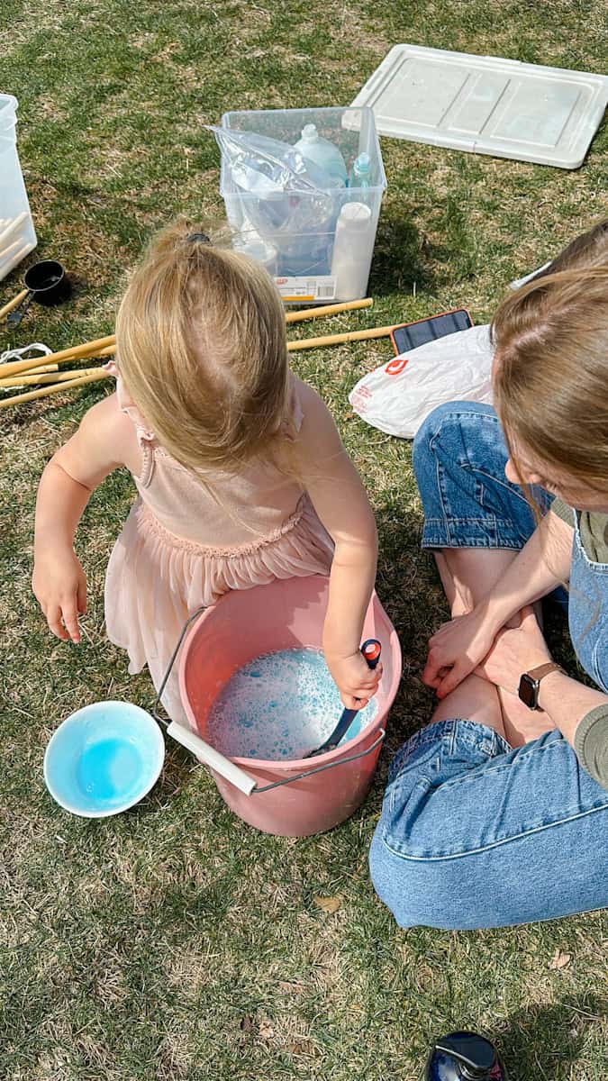 child and mom mixing the homemade bubble solution
