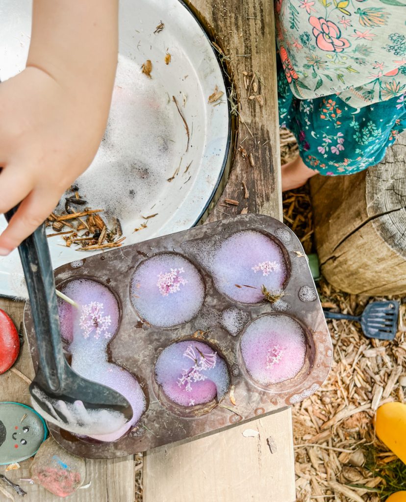 mud kitchen cupcake tin filled with purple bubble foam on the wood table