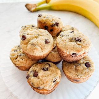 plate of mini banana chocolate chip muffins in front of bananas