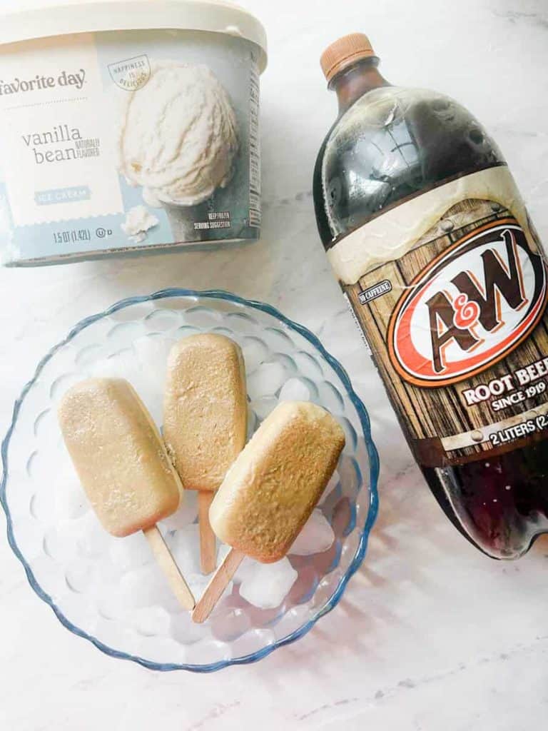 popsicles in a bowl over ice sitting next next to A&W root beer and vanilla bean ice cream