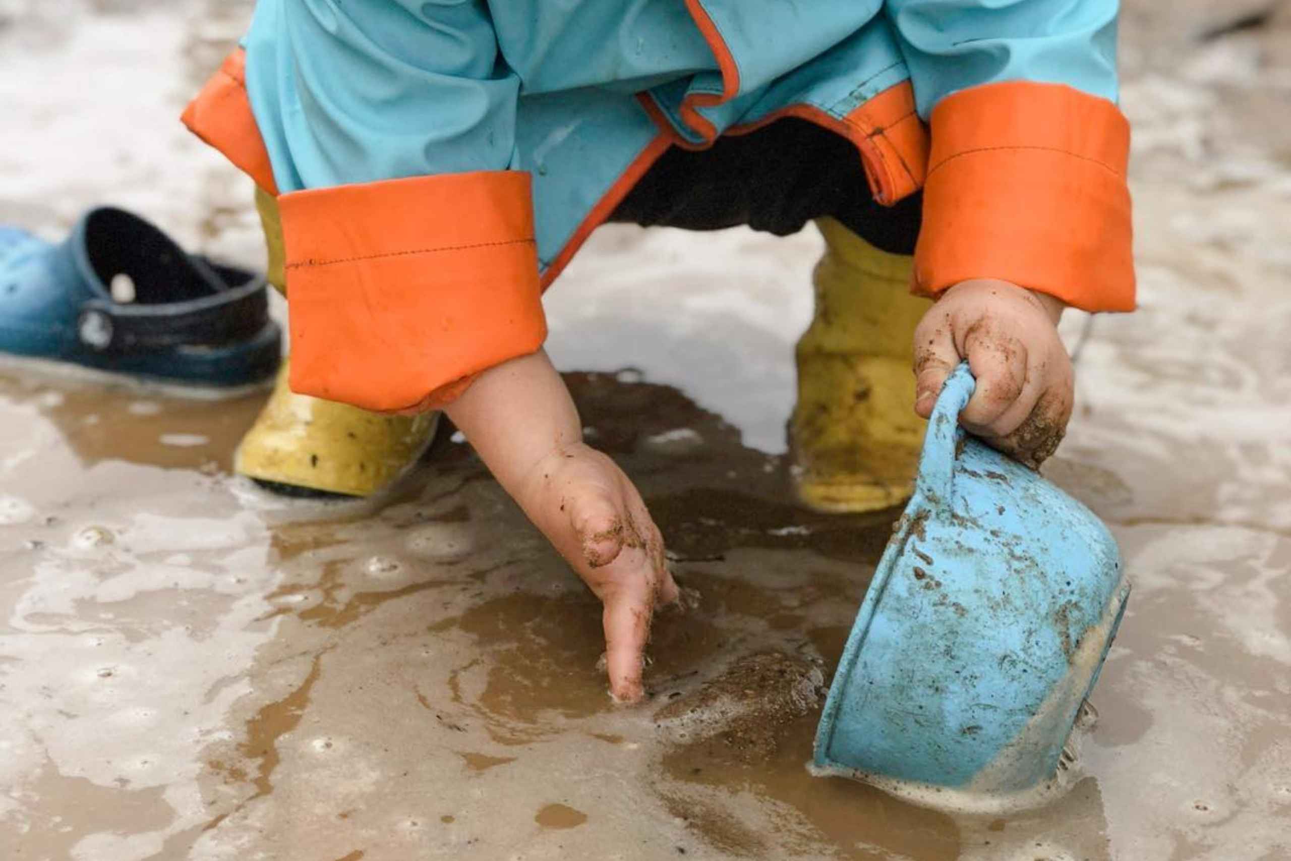child playing in mud outside