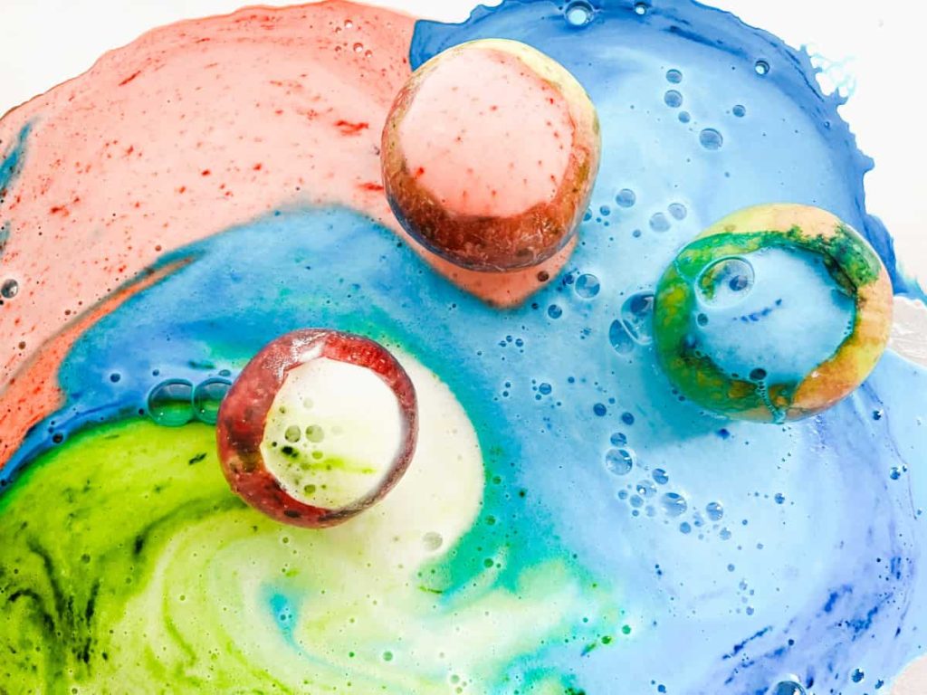 3 overflowing apple volcanoes mixing colors on a pan. Green, blue and red volcanoes.