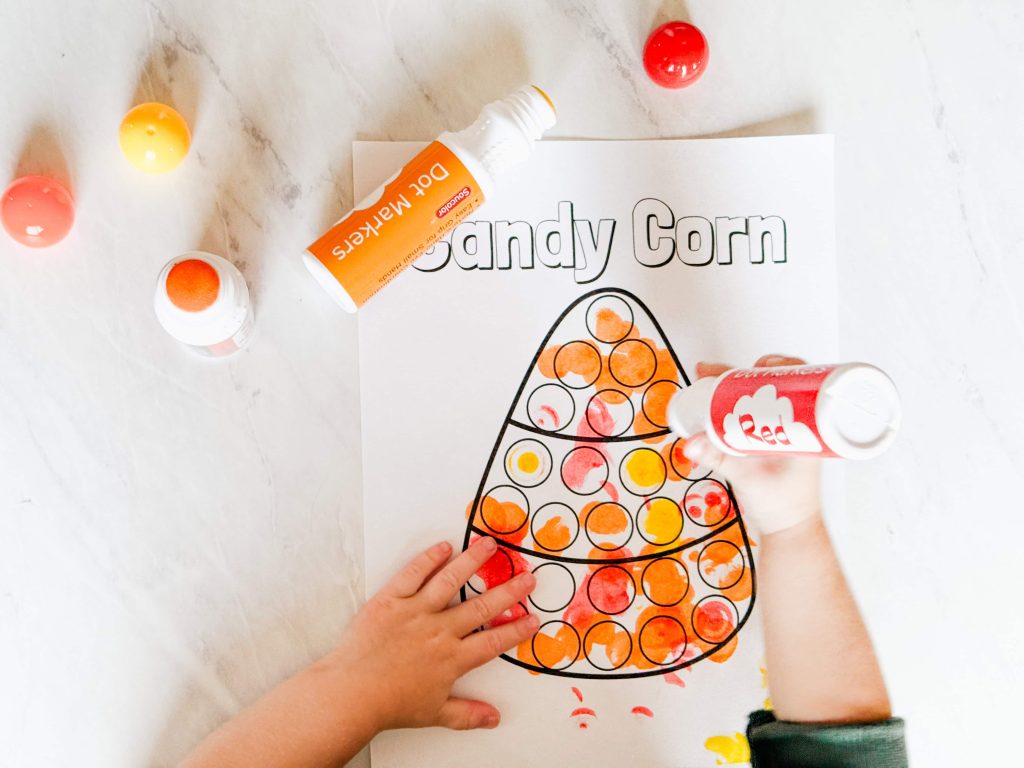 child using teh dot marker to make the candy corn