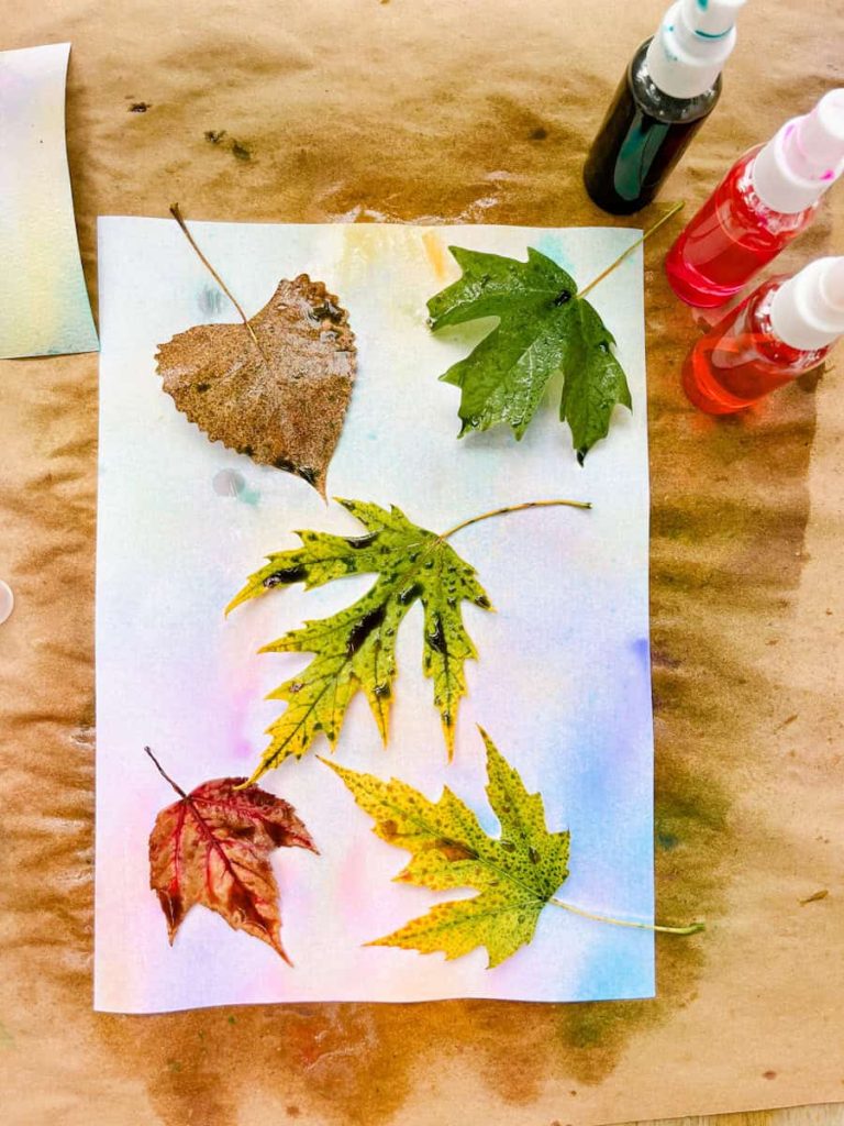 leaves on a piece of paper that has been spray painted 