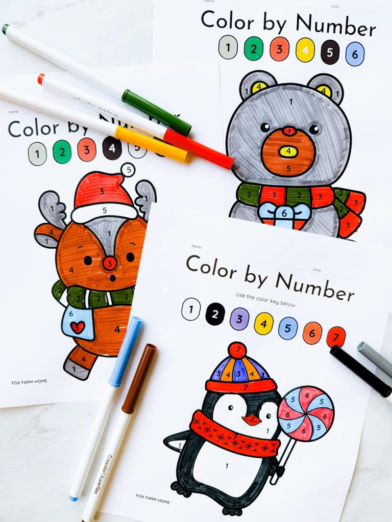 Color by number pages completed on table with markers on it