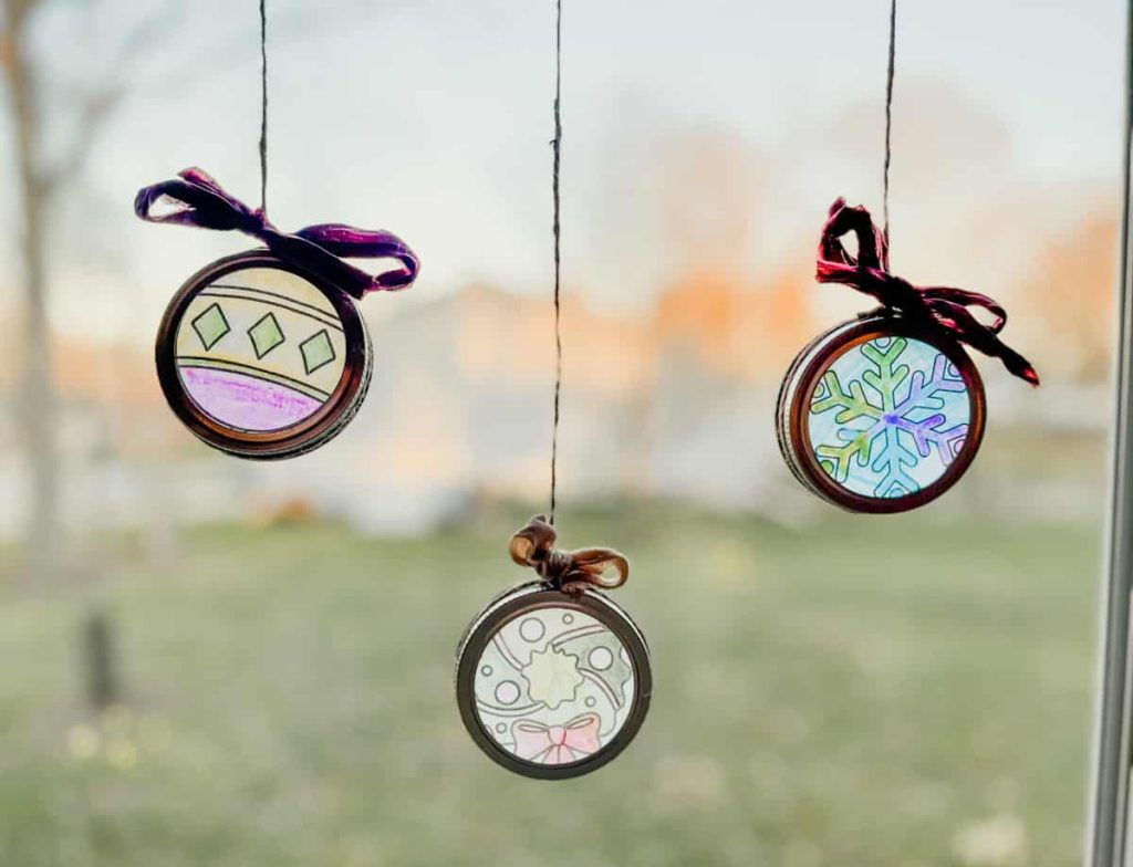 3 christmas ornament suncatchers in window