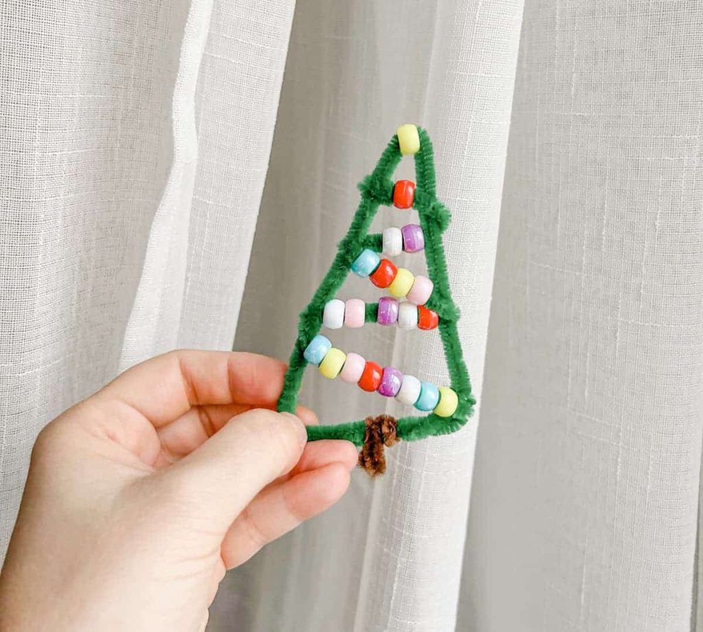 Hand holding the Christmas tree pipe cleaner Christmas ornament