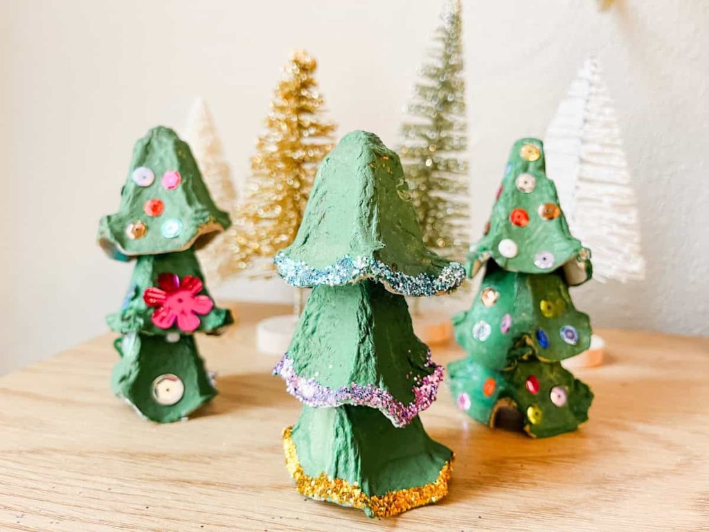 3 finished egg carton christmas trees sitting on table