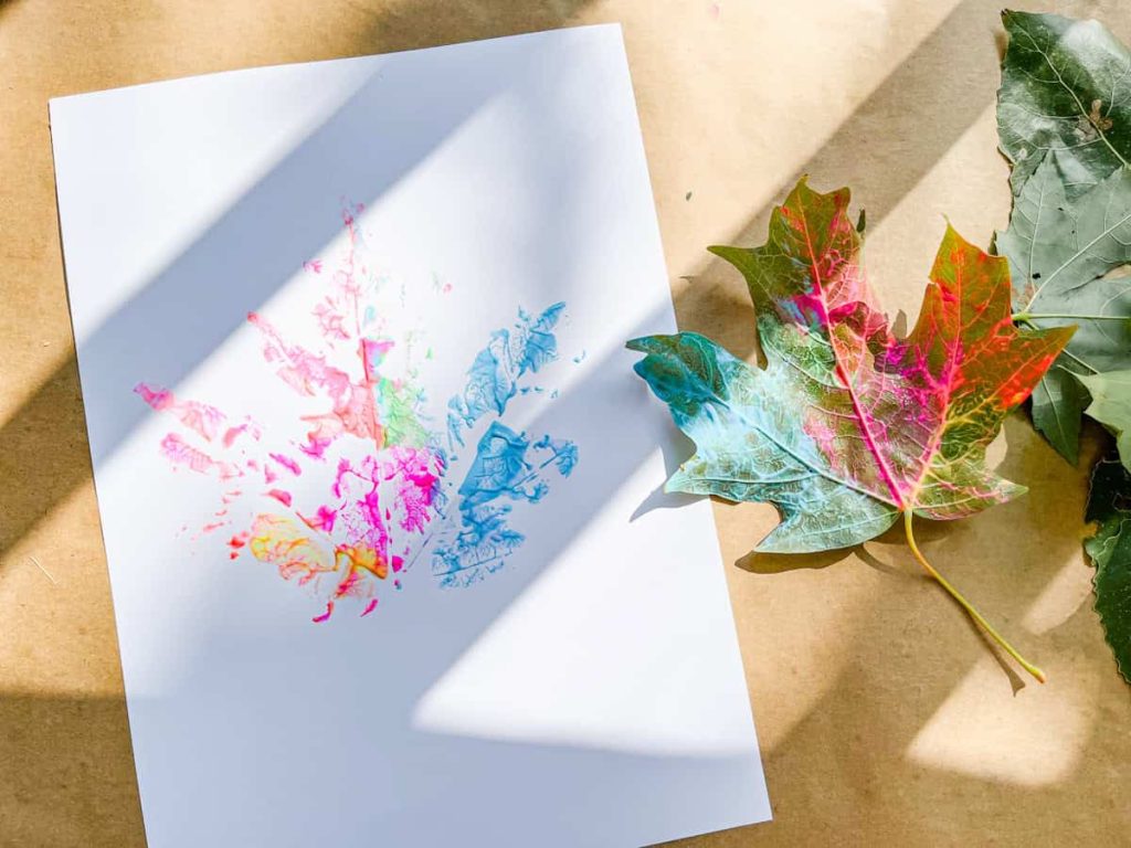 painted leaf next to a finished leaf print on kraft paper