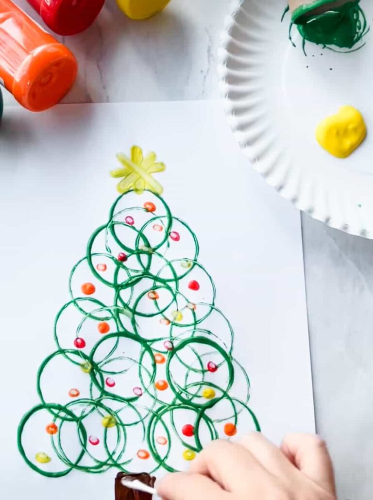 completed toilet paper Christmas roll tree with star on top and hand painting the grunk