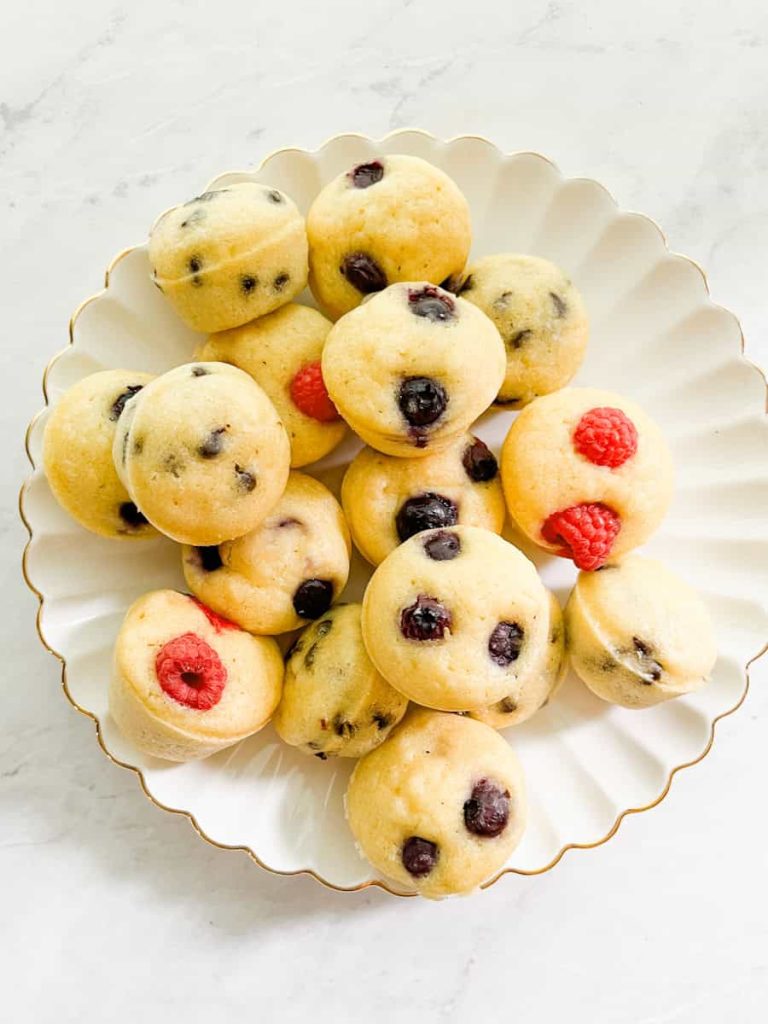 plate of pancake mini muffins with blueberries, chocolate chips and raspberries on top