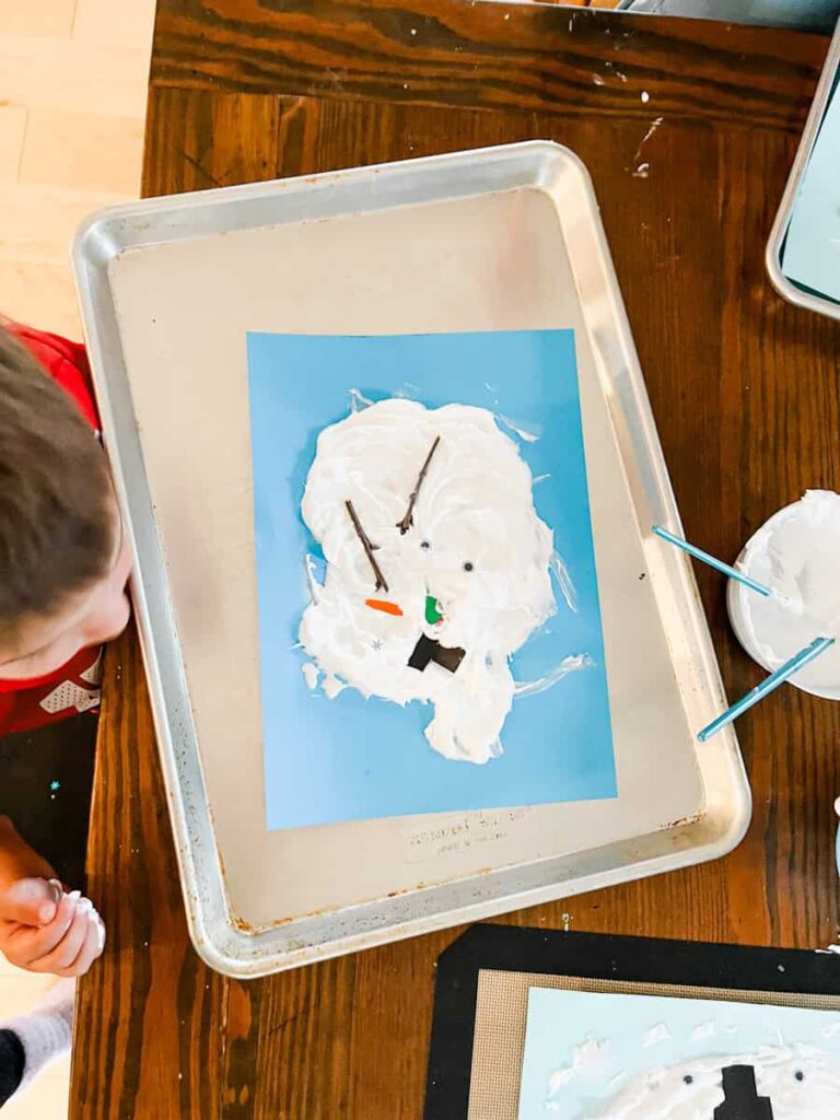 child working on melted snowman craft on a tray at the table