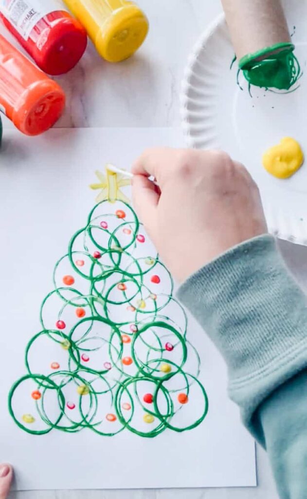 person adding star to the top of the tree