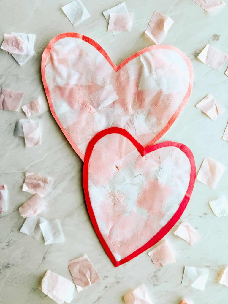 two heart suncatchers laying on table with tissue paper around it