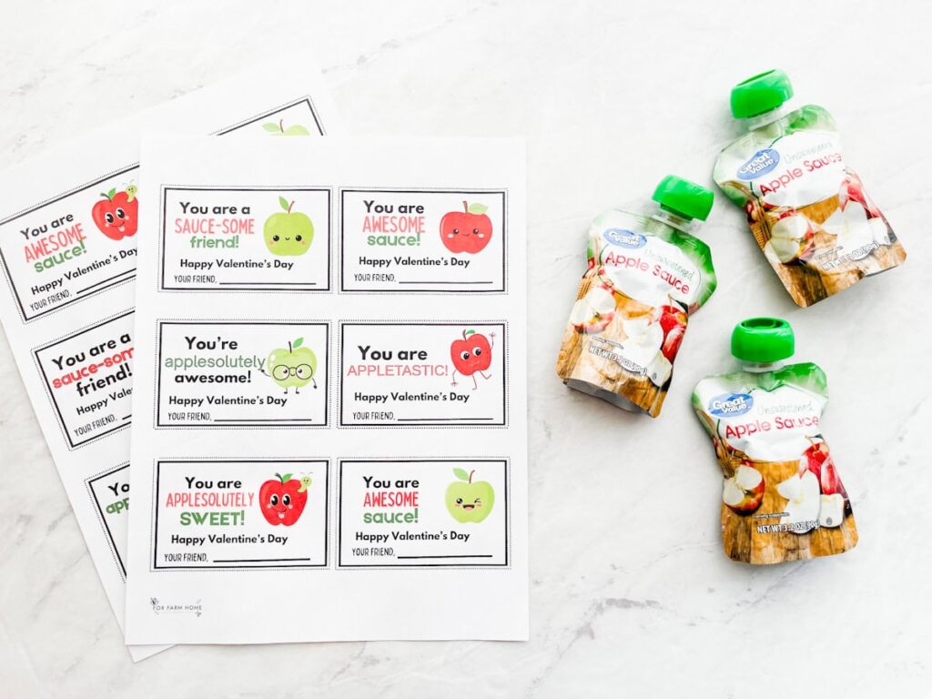 two printable Valentine's Day cards sheets on table with packets sitting next to it