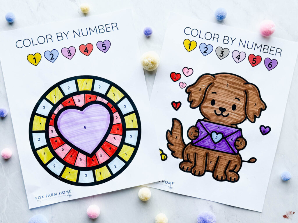 two finished color by number sheets with pom poms around it