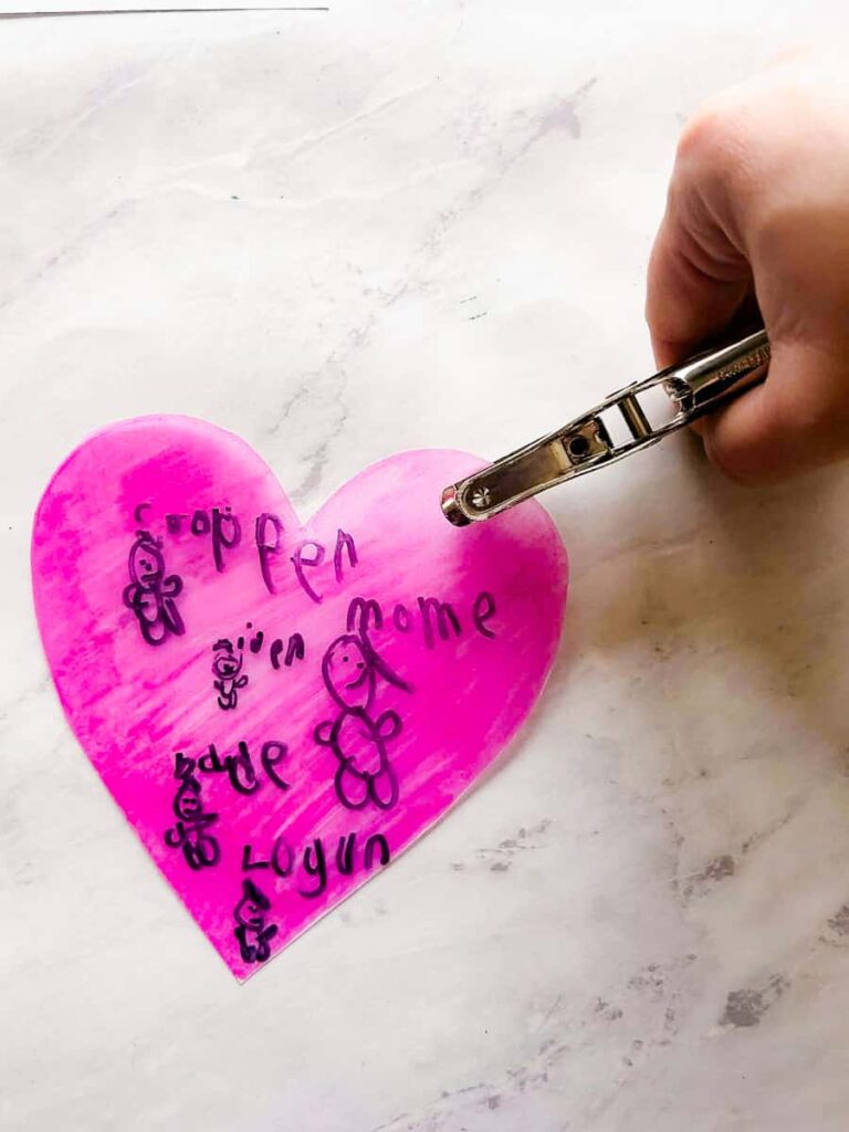 hand punching hole on top of heart