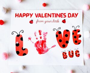 Completed printable love bug craft with handprint as the "o" and on table with pom poms around it