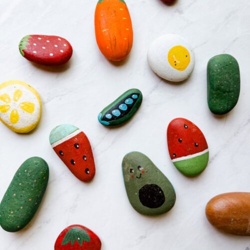 completed painted rocks in a variety of designs of food on table