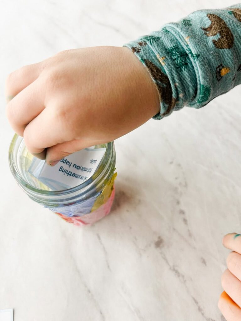 child putting hand in jar to pull out a conversation starter card
