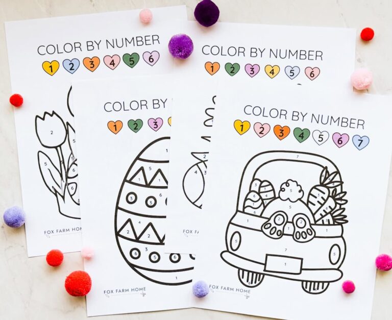 Easter color by number pages sitting out on table with pom poms on table next to them