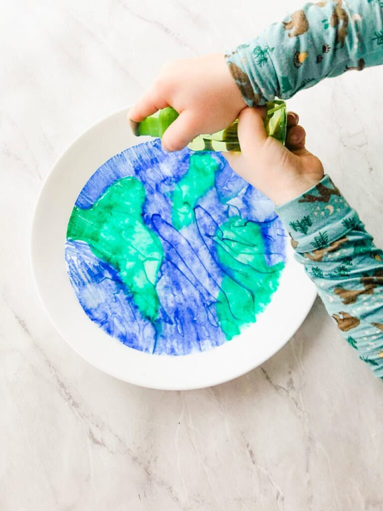 child spraying water on the coffee filter earth