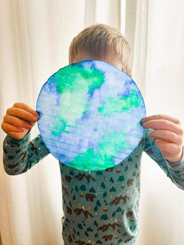 child holding the coffee filter earth suncatcher
