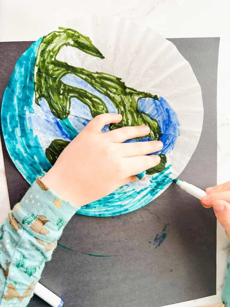 child coloring in the ocean on the coffee filter