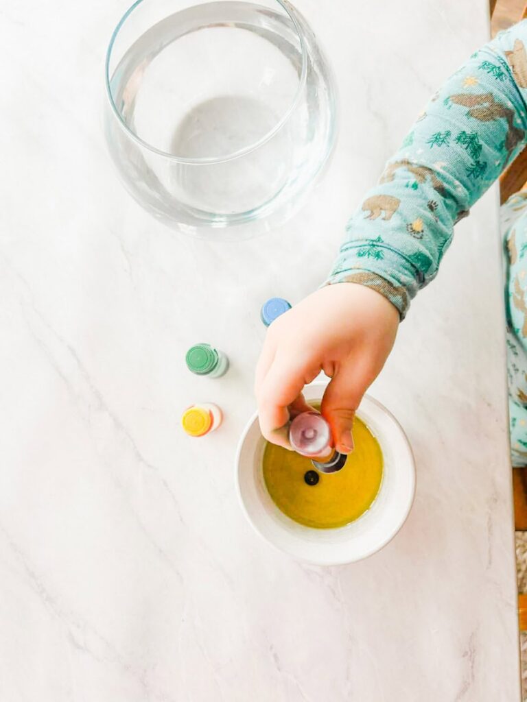 child adding food coloring to the oil