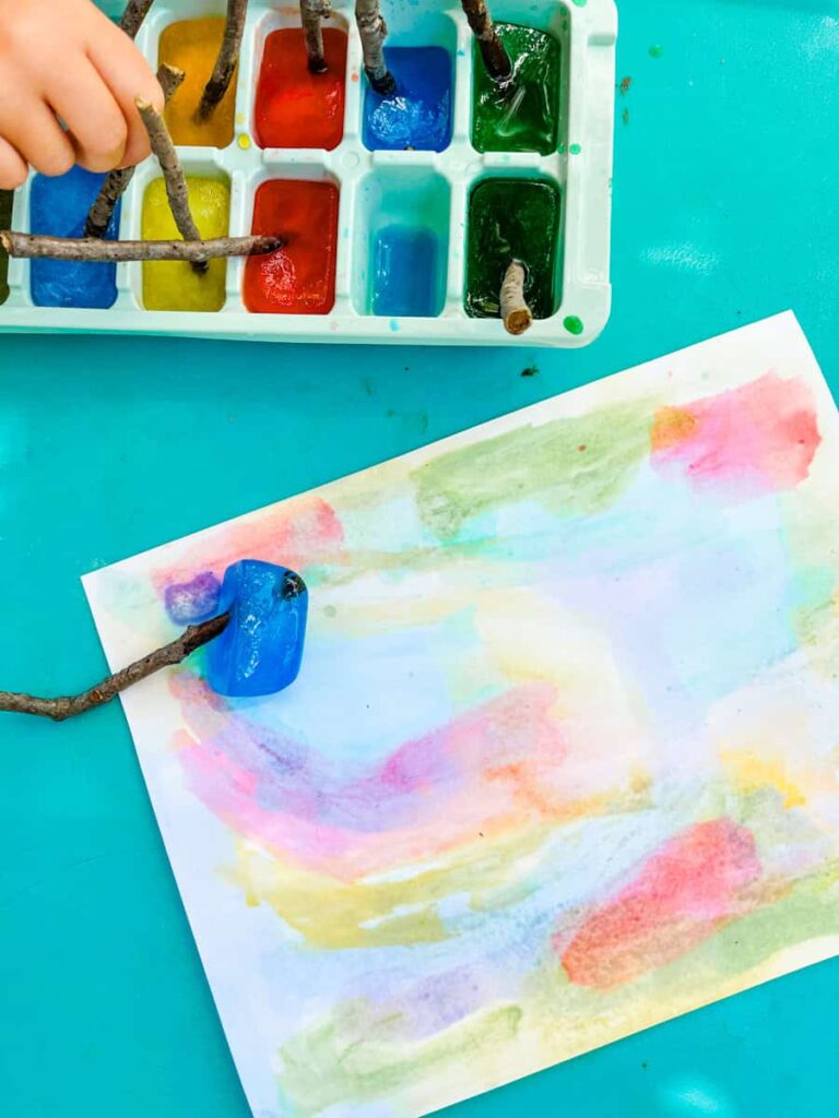 ice paint stick on table with watercolor paper underneath
