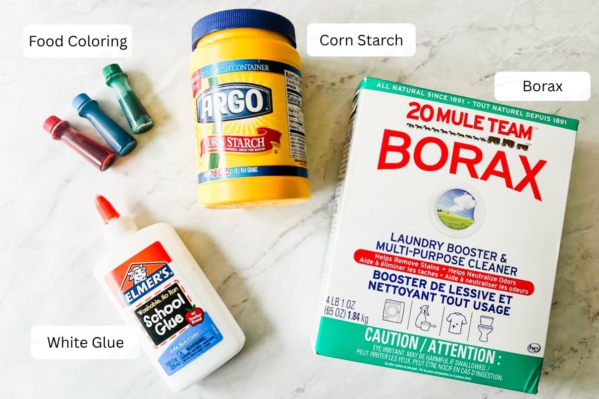 Borax, corn starch, food coloring and white glue sitting on table.