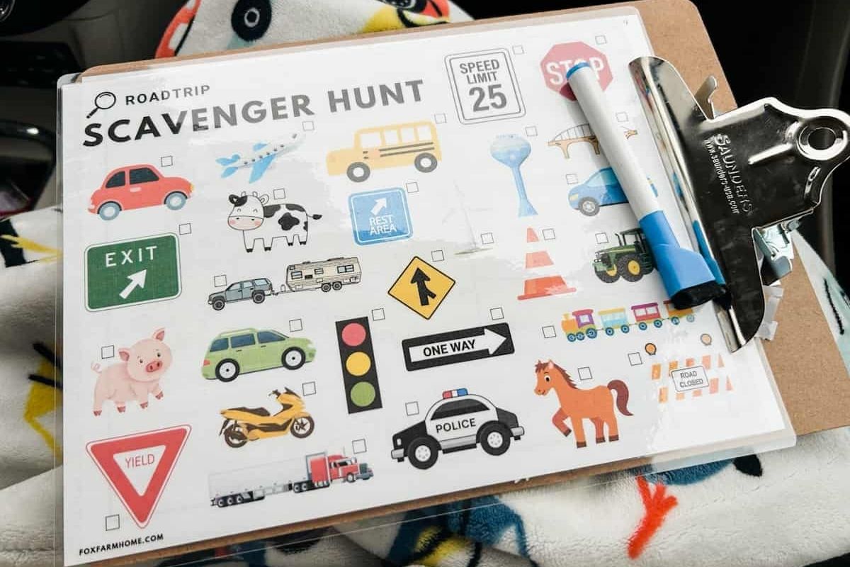 scavenger hunt laminated and on clipboard sitting on top of blanket with whiteboard marker on the clipboard.